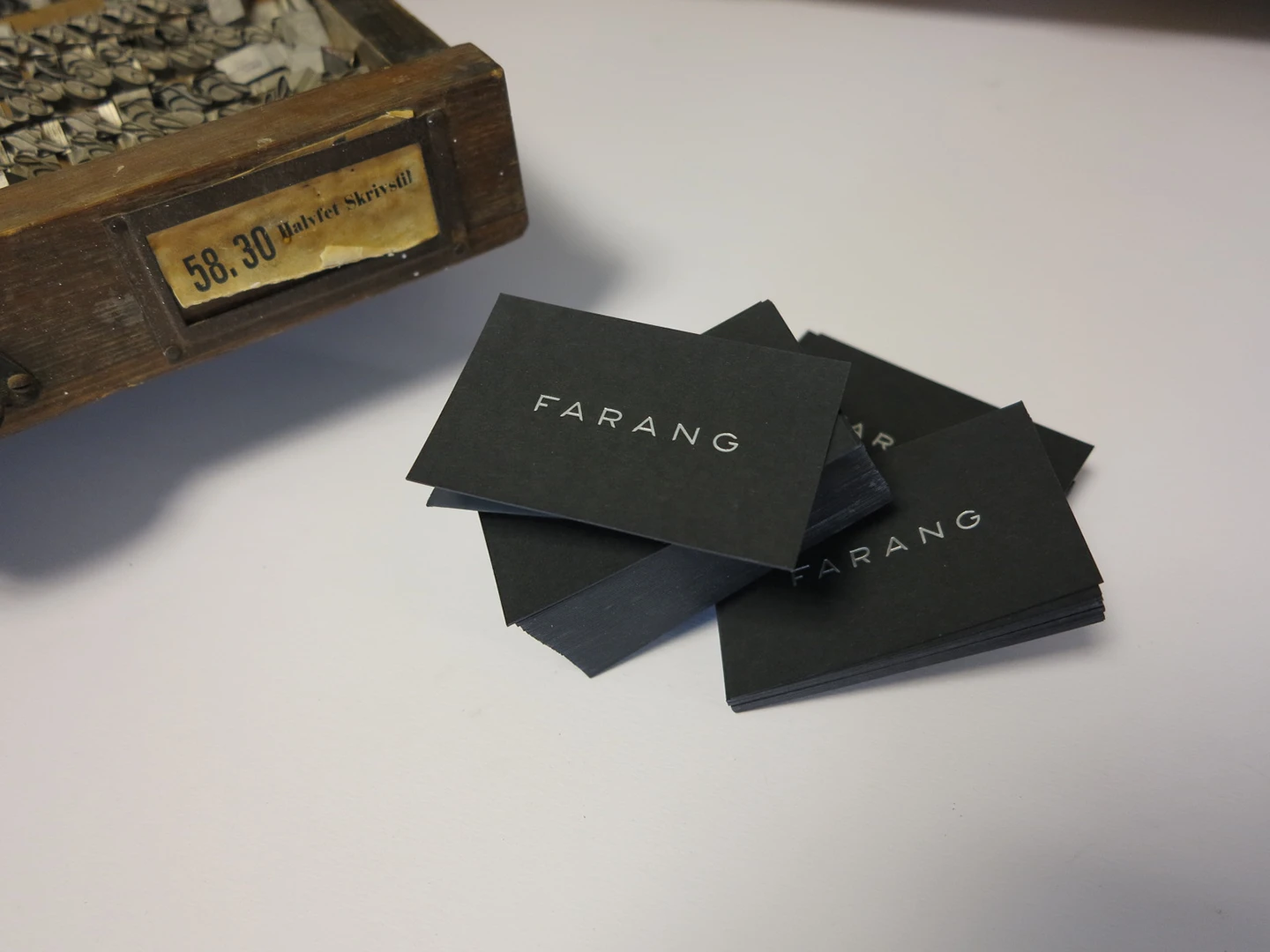 Visitkort tryckt med matt silverfolieprägling på ett matt svart papper Fuego coal black (500 gram)