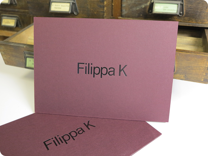 Infokort i A5 format på vinrött Conqueror Burgundy papper (600 gram) med blank svart folieprägling