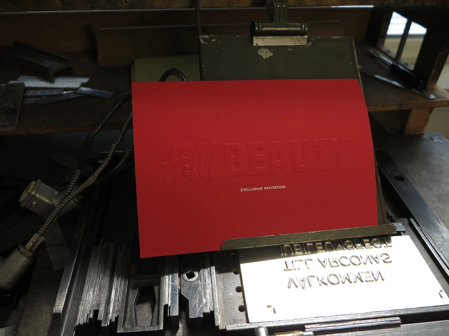 Omslag på rött plike papper (330 gram) med positivt blindpräglad logotype, samt vit folieprägling